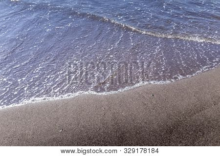 Sea Surf On The Beach With Black Volkanic Sand.