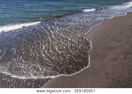 Sea Surf On The Beach With Black Volkanic Sand.