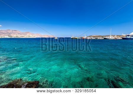 Agios Nikolaos Coastline On A Sunny Day With Clear Sea And Cliffs.