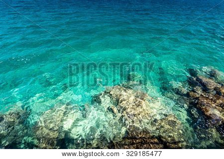 Sea Surf On The Beach With Yellow Stone Bottom And Clear Water.