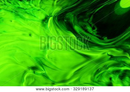 Green Abstract Background. Acrylic Paint Mixed With Water Creates An Interesting Structure. The Pain