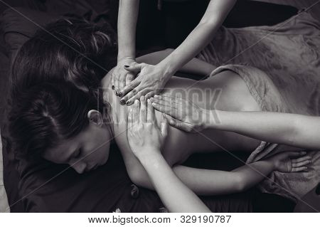 Two Massage Therapist Doing Healing Massage, Massage In Four Hands. Woman Enjoying In Relaxing Massa
