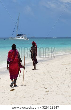 Kendwa, Zanzibar - October 3, 2019: Man From Masai Tribe In Traditional Dress Walks Along Kendwa Bea