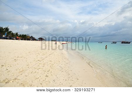 Kendwa, Tanzania - October 5, 2019: White Sandy Beach And Relaxing Tourists In Kendwa Rocks Resort, 