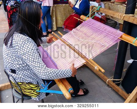 Cuenca, Ecuador - September 28, 2019: Ecuadorian Woman Is Weaving Scarf Or Macana By Hand With Cotto