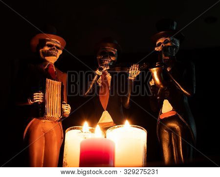 Three Dead Skeleton Musician Playing In The Darkness With Red White Candles Halloween Day Of Dead