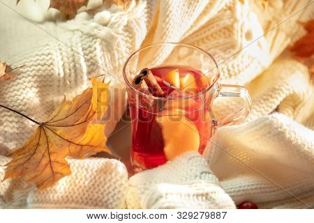 Hot grog, warm sweater and autumn leaves