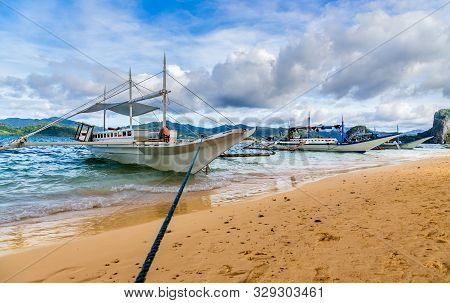 Tropical Island Landscape With Bangca Traditional Phillipinians Boats Anchored At The Shore, Palawan
