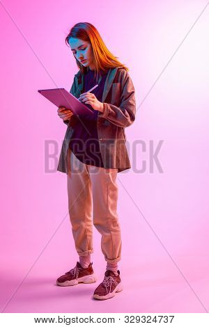 Modern Girl With Laptop, Tablet Computer. Free Creativity. A Young Blogger Makes A Home Office. Colo