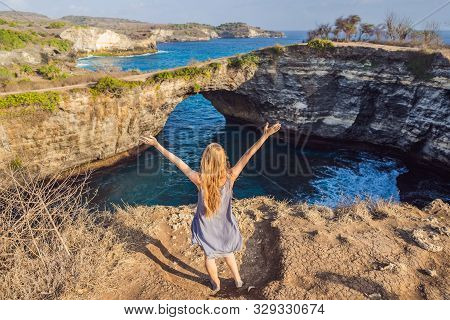 Young Woman Tourist Near Broken Beach In Nusa Penida, Indonesia Angels Billabong Beach. Popular Tour