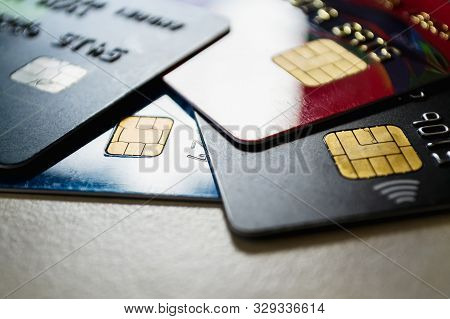 Few Plastic Credit Cards With Chips And Contactless Pay Technology Close-up. Low Key Shot With Old C