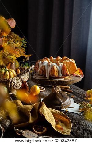 Homemade Tasty Baked Bundt Pumpkin Cake With Glaze On Top On Wooden Cake Stand On Rustic Table With 
