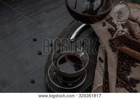 Coffee Style, Cup Of Coffee And Coffee Beans Roating With Old Wooden Scoop And Coffee Beans Around O