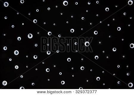 Bunch Of Googly Eyes Plastic Toys Laying On Black Background