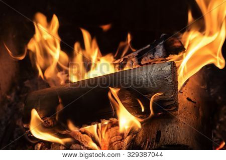 Pieces Of Stump Burning On The Bottom Of A Brazilian Barbecue Grill. Wood Pieces On Flames.