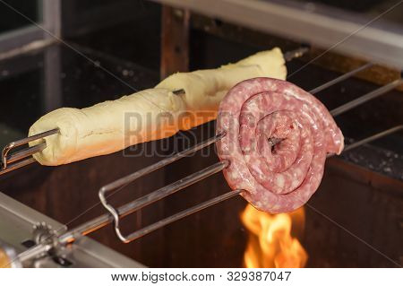 Skewers With Sausage And Garlic Bread Roasting On Fire Of The Barbecue Grill.