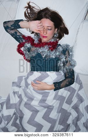 Woman In Bed In A Cocktail Dress After A Loud Party. Hangover, Drunk Sleeping Concept: Young Female 