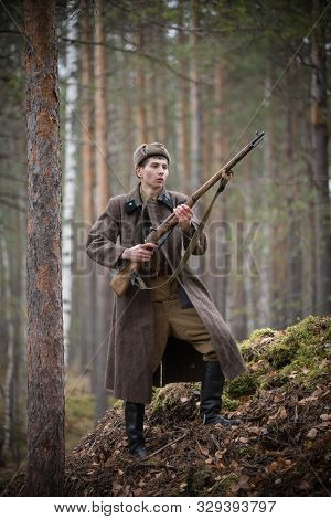 A Soldier Of World War Ii Is Holding The Rifle In His Hands