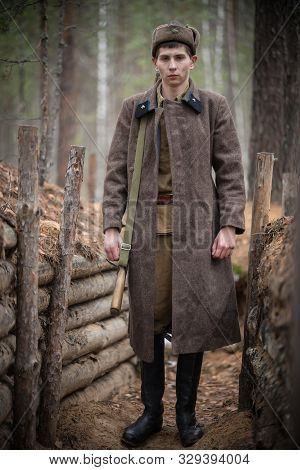A Young Soldier Of World War Ii Is Standing In The Trench