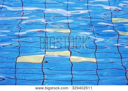 Pure Blue Water In The Pool. Water Background. Swimming Pool Bottom Caustics Ripple And Flow With Wa