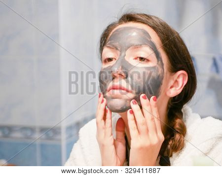 Girl Cares For Oily Skin. Cosmetic Procedures. Skin Care. Young Woman With A Black Mud Mask On Her F