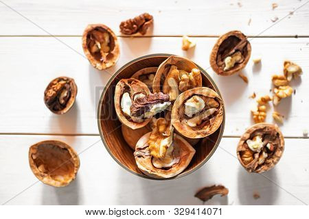 Cleaved And Whole Walnuts On A Light Wooden Background. The Concept Of Healthy Organic Food. Place F