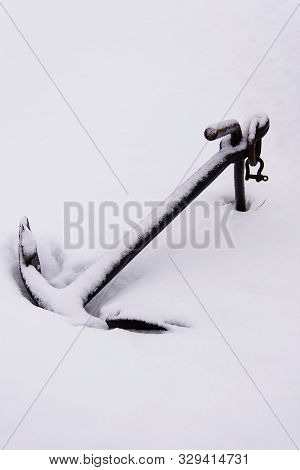 A Ship's Anchor Lies Half-buried In Snow