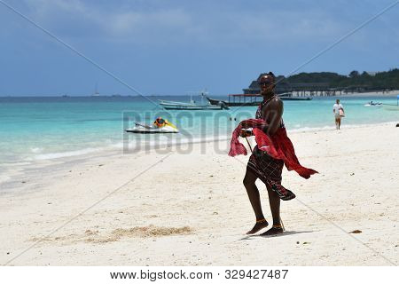 Kendwa, Zanzibar - October 4, 2019: Man From Masai Tribe In Traditional Dress Walks Along Kendwa Bea