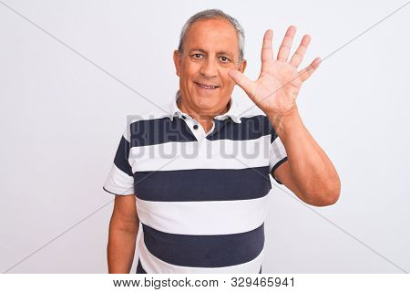 Senior grey-haired man wearing casual striped polo standing over isolated white background showing and pointing up with fingers number five while smiling confident and happy.