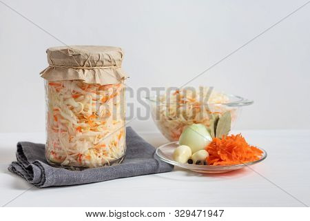 Homemade Sauerkraut. Fermented Food. Sauerkraut With Carrots In A Glass Jar And Bowl On A White Wood