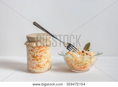 Homemade Sauerkraut. Fermented Food. Sauerkraut With Carrots In Glass Jar And Bowl With Fork On Wood