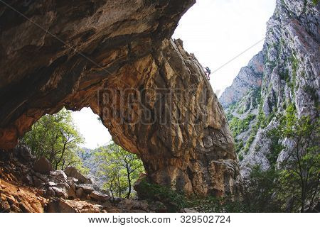 Rock Climbing And Mountaineering In The Paklenica National Park. A Woman Overcomes A Challenging Cli