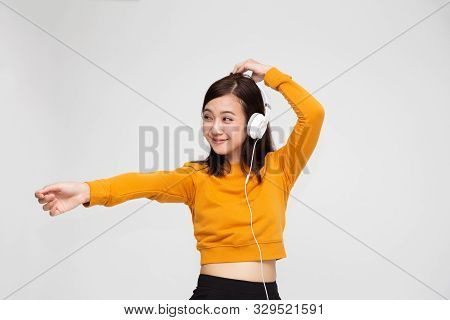 Beautiful Young Asian Woman With Headphones Listening To Music In Bright Outfit Enjoying The Song Me