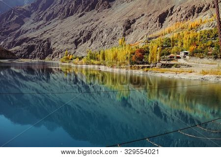Small Village In Gupis Ghizer Valley With A View Of Reflection In Still Water Of Blue Calmness Khalt