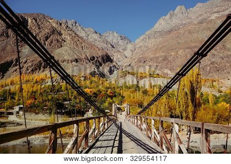 Wooden Suspension Bridge Leads To Khalti Village. Colorful Nature Landscape View In Autumn Season Ag