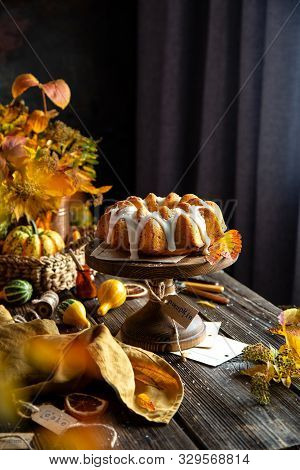 Homemade Tasty Baked Bundt Pumpkin Cake With Glaze On Top On Wooden Cake Stand On Rustic Table With 