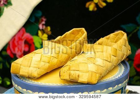 Old Bast Shoes. Traditional Russian Footwear. Shoes From The Bark Of The Tree.