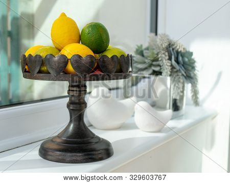 Lemons And Limes In A Bowl On Neutral Windowsill