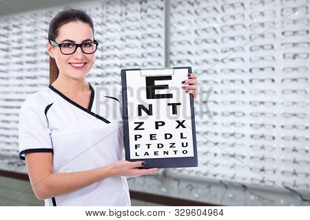 Young Woman Optometrist Or Consultant Holding Clipboard With Eyevision Test Chart At Optics Store