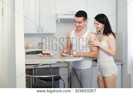 Husband And Wife Cooking Breakfat In Morning On Kitchen, Wearing Shirts.