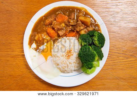Pork Curry Rice On Wooden Background ( Onsen Tamago, Potato, Enoki Mushroom, Onion, Broccoli, Japane