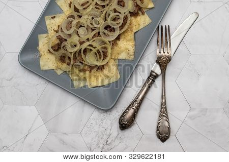 Beshbarmak Is A National Kazakh Dish - Square Pasta With Boiled Meat And Onions. On A Light Backgrou
