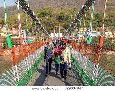 Rishikesh, India - Circa April 2018. Bridge Over Ganga River, Ram Jhula, Rishikesh. People Crossing 