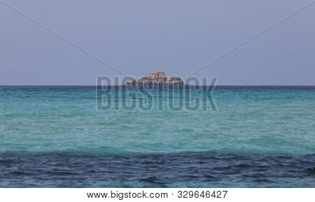 Isolated Island On The Blue Water Of The Ocean In Summer