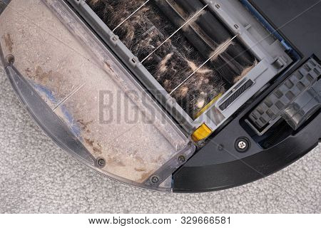 Robot Vacuum Cleaner Clogged With Hair And Dust. Close Up.