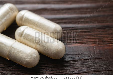 White Medical Capsules Of Glucosamine Chondroitin, Healthy Supplement Pills On Wooden Background, Ma