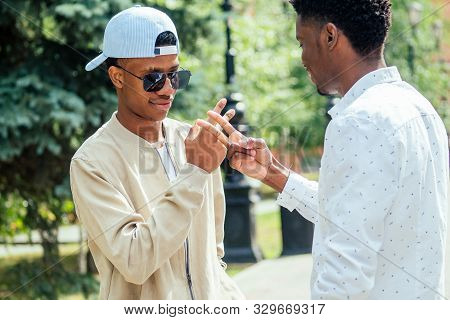 Two Stylish Young Friends Hugging Long-awaited Meeting In Street Parking