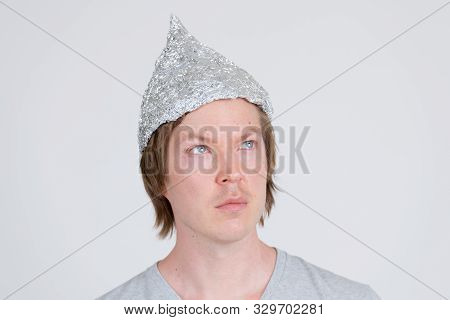 Face Of Young Man With Tinfoil Hat Thinking As Conspiracy Theory Concept