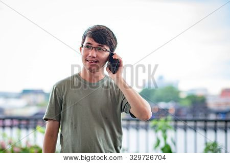 Man calling phone on the riverside view point