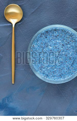 Blue Spirulina Or Butterfly Pea Flower Blue Matcha Powder Chia Seed Pudding Bowl And Golden Spoon. C